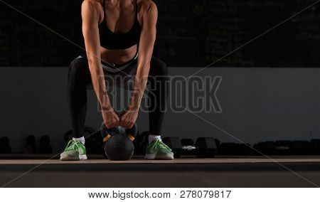 Close-up - Athletic Young Woman Working Out In Gym. Muscular Female Adult Exercising With Kettle Bel