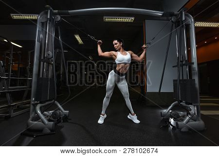 Pretty Young Woman Is Relaxing Near The Cabel Machine Looking Down In The Gym