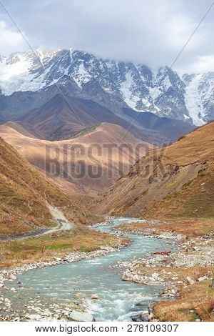The Valley Of The Enguri River In Autumn. The Highest Peak Of Georgia Is Shkhara. Main Caucasian Rid