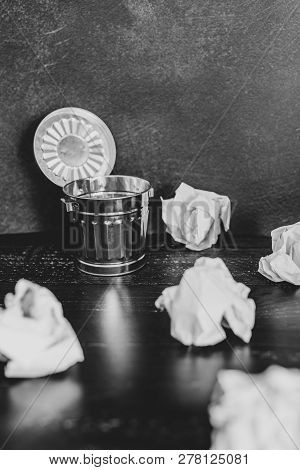 Garbage Bin On Desk Setting And Scrunched Paper Balls Around It, Concept Of Drafting And Struggling 