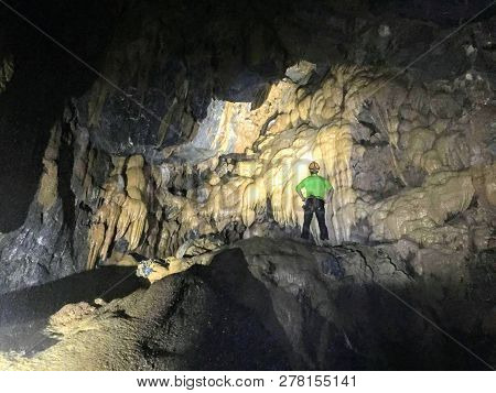 Hang Va Cave, Phong Nha National Park, Vietnam - May 23rd, 2017: A Vietnamese Tour Guide Shines His 