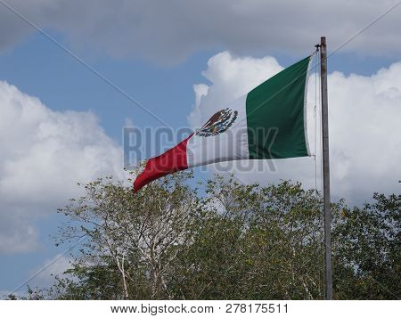 National Maxican Flag At Chichen Itza City Near Marvelous Archaeological Site In Mexico With Trees A