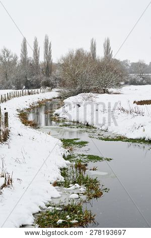 River In A Snow Covered Field