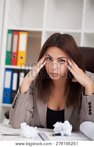 Headache And Stress At Work. Portrait Of Young Business Woman At Her Office