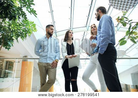 Young Modern Colleagues In Smart Casual Wear Having A Brainstorm Meeting While Standing In The Creat
