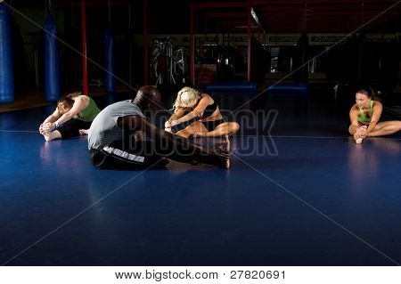 Womans MMA squadra e allenatore allunga durante un warm up in una palestra di boxe