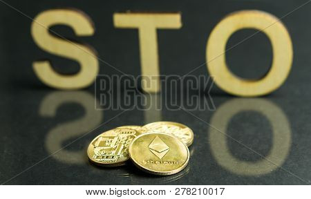 Security Token Offering Sto Sign With Wooden Letters And Gold Coins In Front Of It, Ethereum Concept