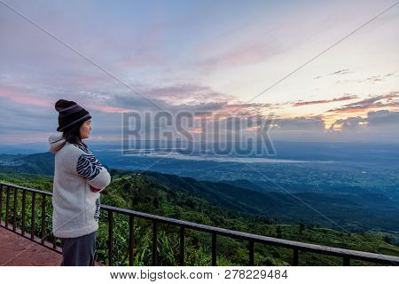 Woman Tourist In A Sweater Dress Standing Watching The Beautiful Nature Landscape Of The Forest And 