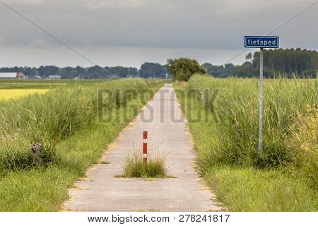 Cycling Track Or Fietspad Through Green Flat Open Polder Landscape In Groningen Province Netherlands
