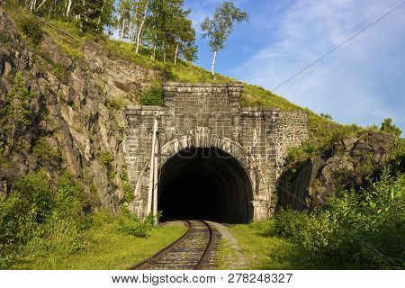 Stone Arch Tunnel In Mountain On The Circum-baikal Railway. Summer Landscape For Travel In Enigmatic