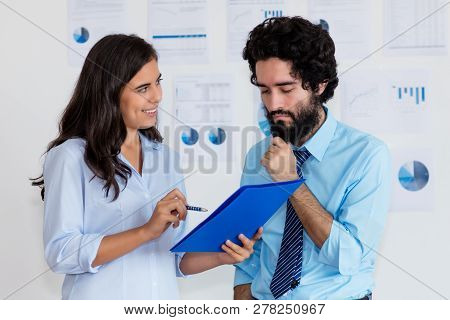 Laughing Turkish Businesswoman And Thinking Arabic Businessman At Office Of Company