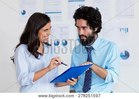 Arabic Businessman With Turkish Businesswoman With Paperwork At Office Of Company