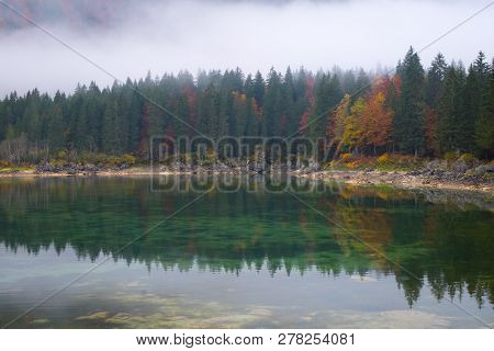 Beautiful Reflections Of Colorful Forest On Lake Laghi Di Fusine On A Foggy Morning In Autumn Near T