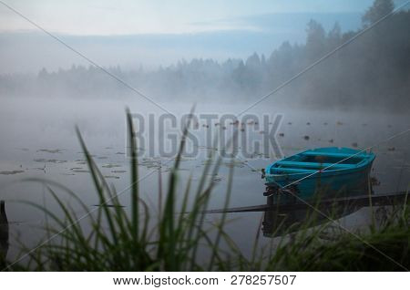 Lonely Boat On A Peaceful Lake. Foggy Autumn Sunrise Twilight. Bright Blue Turquoise Shallop Quiet F