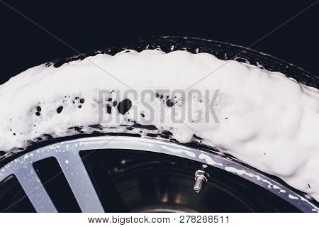 Car Care Or Car Detailing Process. Using Black Sponge To Washing The Tire. Blacker Rubber.