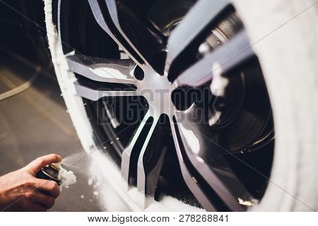 Car Care Or Car Detailing Process. Using Black Sponge To Washing The Tire. Blacker Rubber.