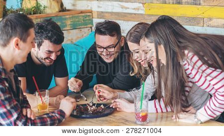 Happy Friends Sharing Slice Of Cake At Bar Restaurant - Friendship Concept With Young People Enjoyin
