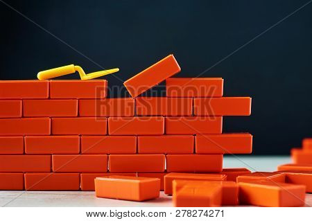 Finishing Task Concept. Brickwork And Building Trowel On Dark Background