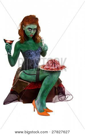 Sexy zombie femmina seduti a bere un martini e cervelli umani con una forchetta