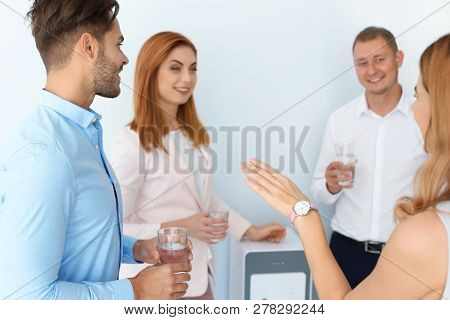 Co-workers Having Break Near Water Cooler On White Background