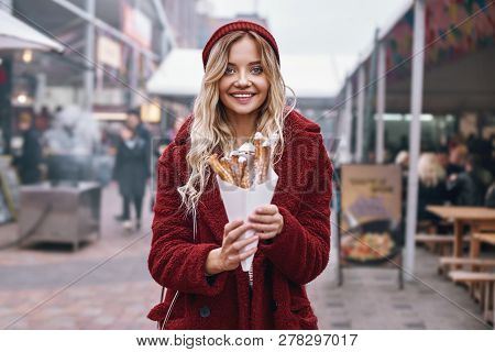 Close-up Of Young Blonde Woman Eatting Churros
