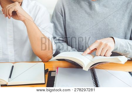 High School Or College Students Studying And Reading Together In Library