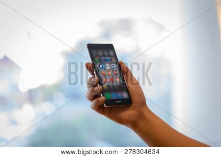 Chiang Mai, Thailand - Oct. 28,2018: Man Holding Huawei With Icons Of E-commerce And Online Shopping