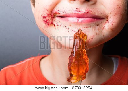 Boy Sucks Lollipop, Baby Eats Red-orange Chupa-chups, Mouth, Pink Lips, Candy In Hand