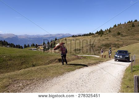 Compaccio Compatsch, Italy On September 12. View Of Hikers, Tourists On A Gravel Road On September 1