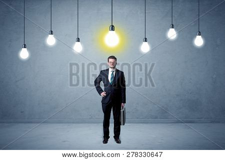Handsome businessman in an empty space with bulbs above and uninspired face