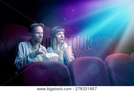 Teenager couple cuddling and watching the climax part of the movie