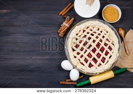 Raw Cherry Pie In A Glass Round Form And Ingredients For Making Cake  - Flour, Egg, Cherry, Brown Su