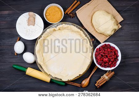 Pie Base In A Glass Round Form And Ingredients For Making Cake  - Flour, Egg, Cherry, Brown Sugar, C