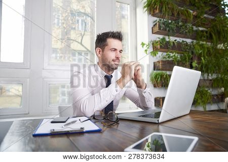 Businessman Sitting In Front Of Laptop And Thinking