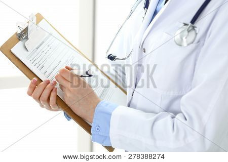 Female Doctor Using Medical Form On Clipboard Closeup.  Physicianat Work In Hospital Or Clinic. Heal