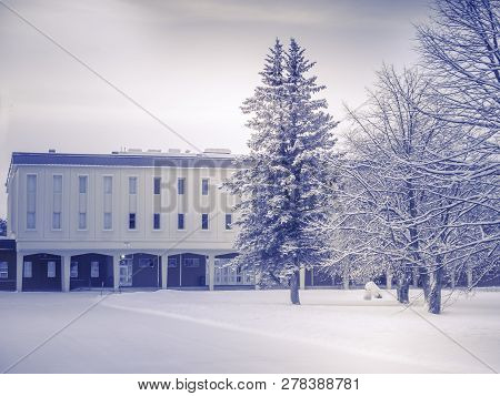 This Building Is Only Part That We See. It Is Shaped Like A Square. The Trees Around Decorate The Ci