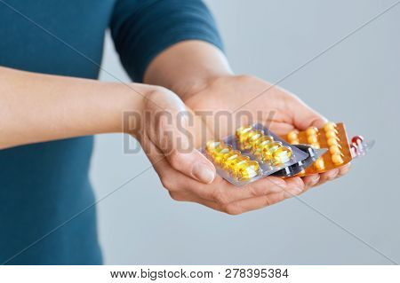 Vitamins And Supplements. Closeup Of Female Hand Holding Variety Of Colorful Pills On Palm. Close-up