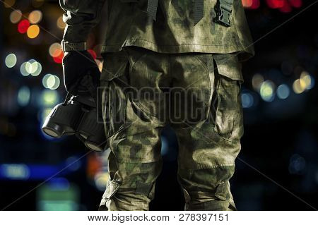 Special Unit Soldier Holds A Night Vision Device In His Hand.