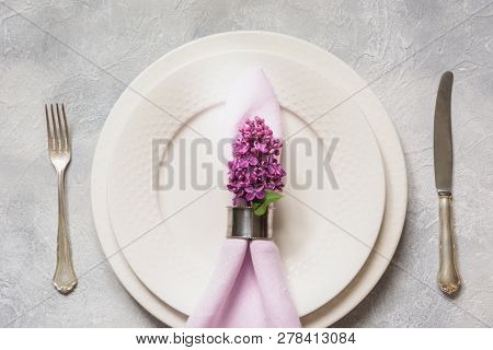 Spring Table Place Setting With Lilac Flowers, Silverware On Light Table. Top View.