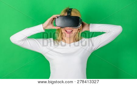 Woman Wearing Virtual Reality Goggles In Green Background. Happy Woman Exploring Augmented World, In