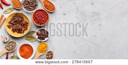 Dried Spices And Seasonings In Bowls On Grey Background, Copy Space, Top View