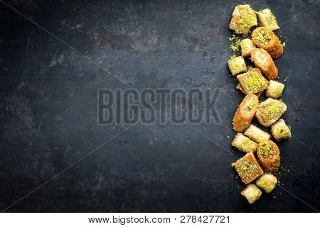 Traditional Oriental baklava collection as top view on a black board with copy space left