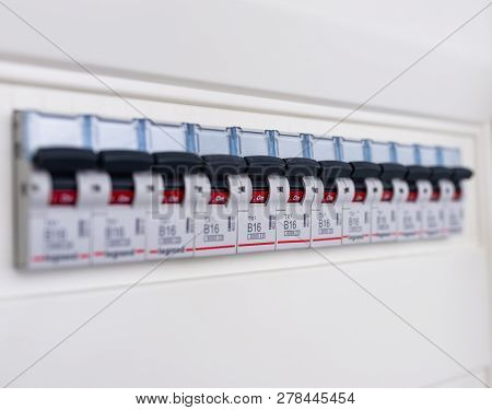Switches In Electrical Fuse Box. Many Black Circuit Breakers In A Row In Position On. Power Control 