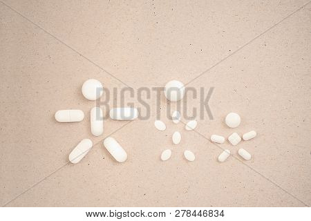 People Made From Pills On The сardboard Background. Concept