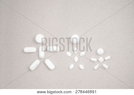 People Made From Pills On The сardboard Background. Concept