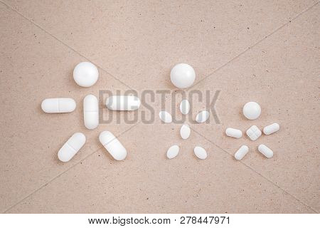 People Made From Pills On The сardboard Background. Concept