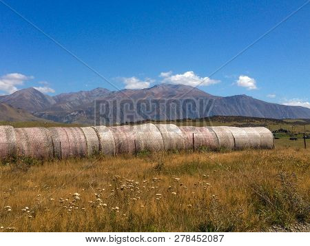 Hay Bales In Front Of Mountains On The South Island Of New Zealand