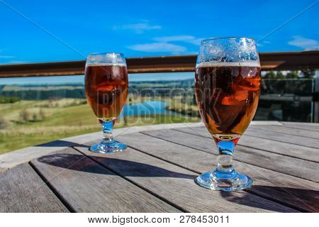 Two Glasses Of Beer On A Wooden Table At Outside Area, New Zealand