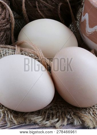 Close-up Of Three Easter Eggs And Thread. Portion Of Ceramic Cup And Knitting Yarn