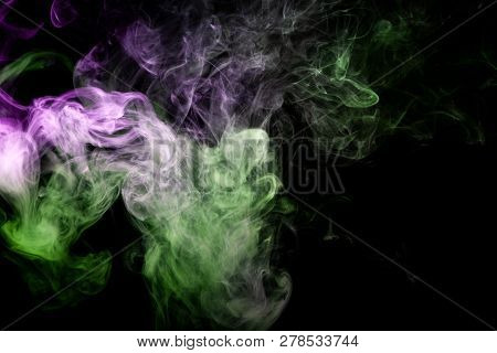 Thick Green And Purple Smoke On A Black Isolated Background. Background From The Smoke Of Vap